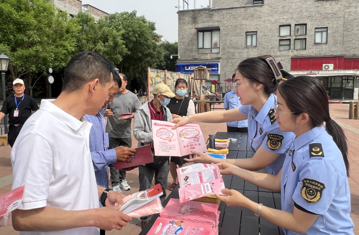 圖為該局監(jiān)管人員向社區(qū)居民發(fā)放化妝品科普手冊(cè)。