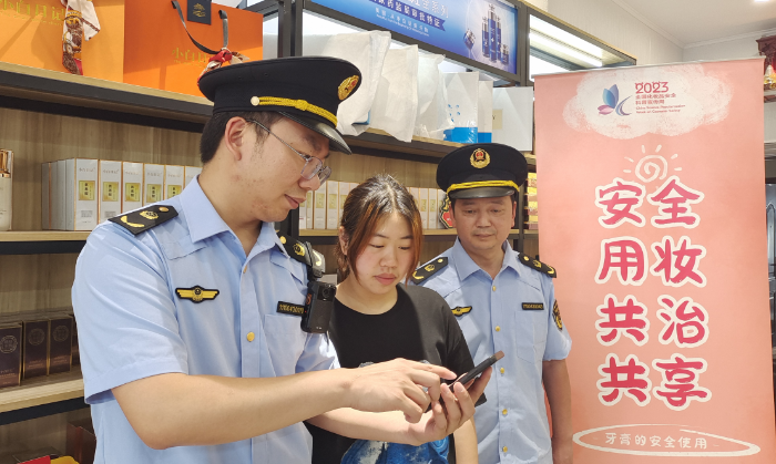 圖為執(zhí)法人員指導(dǎo)經(jīng)營戶使用“數(shù)字辨妝”一體化監(jiān)管平臺(tái)的云管理模塊。