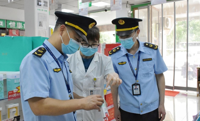 圖為該局執(zhí)法人員正在轄區(qū)內(nèi)一家藥店檢查核對相關(guān)藥品銷售信息。