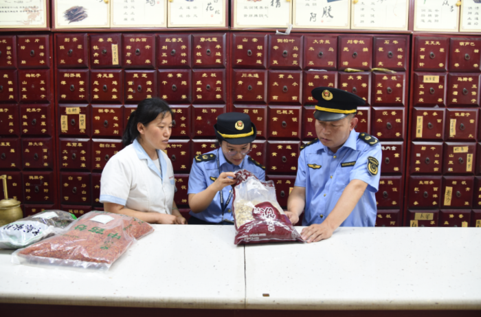 圖為該局執(zhí)法人員在一家藥品零售企業(yè)檢查在售中藥飲片質(zhì)量。