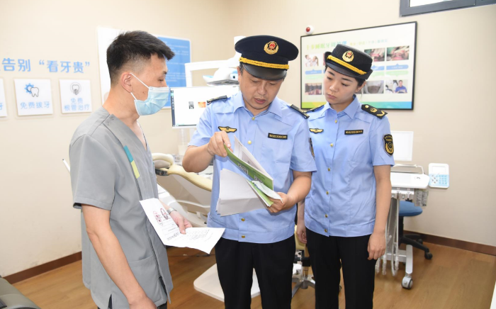 圖為該局執(zhí)法人員在一家口腔診所檢查其藥械采購索證索票情況。