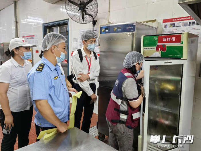 開福區(qū)市場監(jiān)督管理局和區(qū)疾控中心等工作人員前往學校食堂，抽樣檢查了可疑的食品留樣和餐具。長沙晚報通訊員　黃勇軍　攝