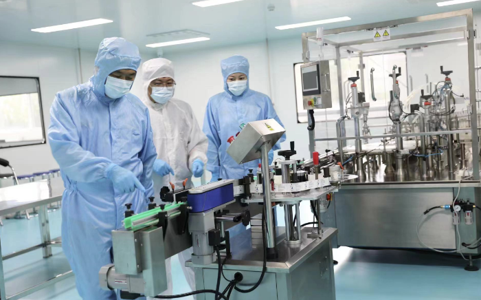 圖為執(zhí)法人員在一家醫(yī)療器械生產(chǎn)企業(yè)查看生產(chǎn)線情況。