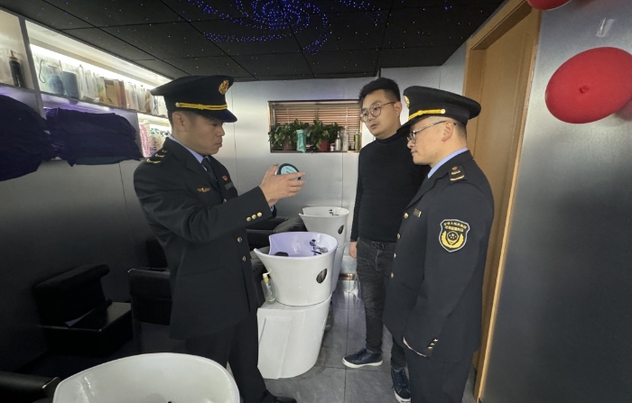圖為執(zhí)法人員正在一家美容美發(fā)機構(gòu)進行現(xiàn)場檢查。