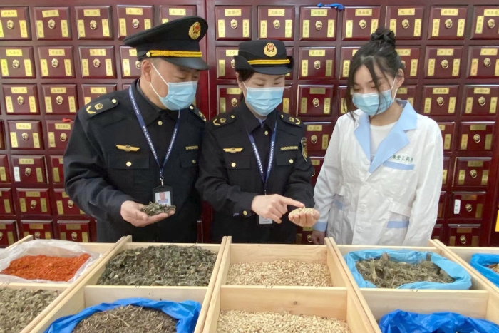 圖為執(zhí)法人員檢查中藥飲片。