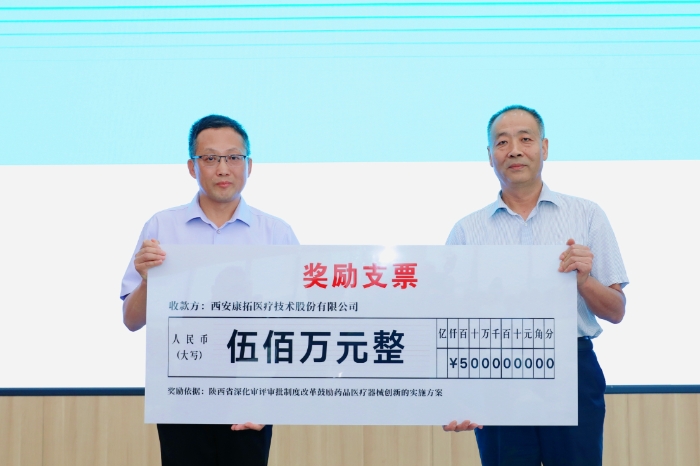 圖為研討會現(xiàn)場，陜西省藥監(jiān)局二級巡視員王志宏向西安康拓醫(yī)療技術(shù)股份有限公司董事長胡立人頒發(fā)500萬元醫(yī)療器械創(chuàng)新獎勵資金。