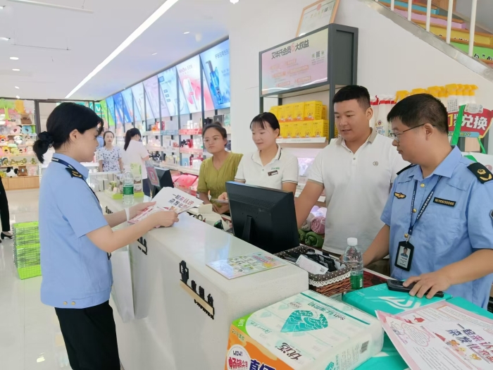 圖為執(zhí)法人員在一家商場發(fā)放宣傳材料。