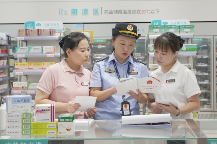圖為8月28日，該局執(zhí)法人員向藥店經(jīng)營者解讀《藥品管理法》。（劉曉紅 董黎攝）.jpg