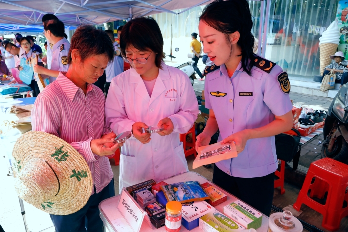 工作人員為群眾講解如何識別假冒偽劣藥品。（何正君攝）