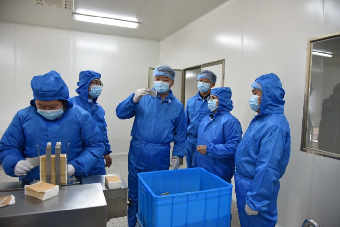 圖為甘肅省藥監(jiān)局黨組書記、局長吉永鋒（右四）帶領(lǐng)調(diào)研組在白銀振亞衛(wèi)生材料有限公司查看祖師麻關(guān)節(jié)止痛膏生產(chǎn)情況 。 （盧昌貴 攝）