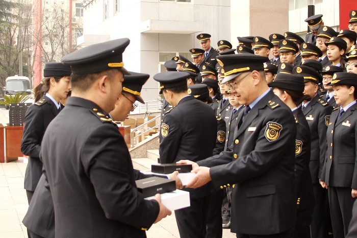 圖為儀式現(xiàn)場，陜西省藥監(jiān)局領(lǐng)導(dǎo)向執(zhí)法人員代表發(fā)放了執(zhí)法裝備（賀一辰攝）