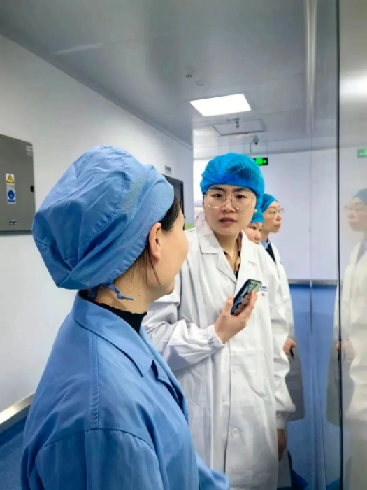 1月24日，中國醫(yī)藥報記者蔣紅瑜（右一）在桂林南藥生產車間采訪抗瘧藥品生產線改造情況